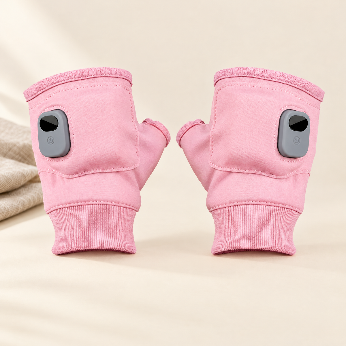 Heated fingerless gloves in pink on cream background